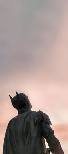 a man in a batman costume looking up at the sky