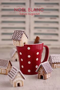 a cup filled with hot chocolate sitting on top of a table next to small houses