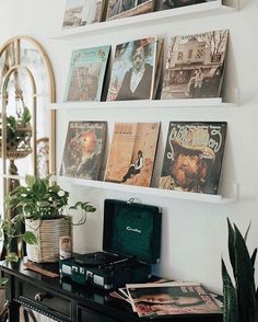 there are many books on the shelves above the desk and in front of it is a record player