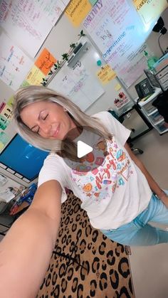 a woman is taking a selfie in front of a computer screen with her hands behind her head