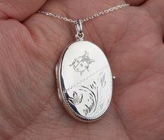 "Carrying the pictures of your loved ones close to your heart all the time, this large personalized locket necklace features: 1. a large (33 x 23 mm without bale) oval solid sterling silver locket (8.5 grams) Its front's lower portion is etched with a floral pattern. The upper portion and the back (plain) can be engraved (use pulldown menu to select) with monograms, text, or graphics (limited to black/white, line drawing type). handwriting or fingerprint * * fingerprint engraving will incur $10 Engraved Oval Locket Necklace For Personalized Gift, Oval Engraved Locket Necklace For Personalized Gift, Oval Engraved Locket Necklace For Memorial, Hallmarked White Gold Locket Necklace For Wedding, White Gold Hallmarked Locket Necklace For Wedding, Wedding White Gold Hallmarked Locket Necklace, Oval White Gold Locket Necklace For Wedding, White Gold Oval Locket Necklace For Wedding, Hallmarked Oval Pendant Locket Necklace For Wedding