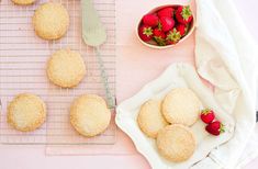 strawberry shortbreads on a cooling rack with strawberries and a bowl of strawberries