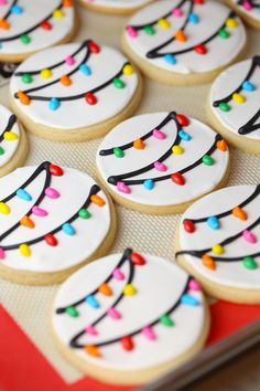 decorated cookies with icing and multicolored lights are on a baking sheet, ready to be eaten