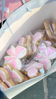 a box filled with pink and white decorated cookies