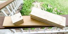 three pieces of wood sitting on top of a wooden bench next to a hand rail