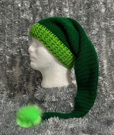 a knitted hat with a green pom - pom attached to the brim