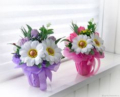 three vases filled with flowers sitting on a window sill next to each other