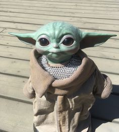 the child yoda doll is wearing a sweater