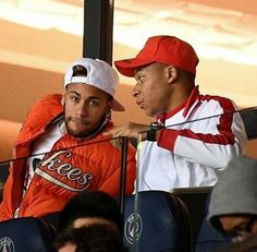 two baseball players sitting next to each other in the dugout with their hands on their hips