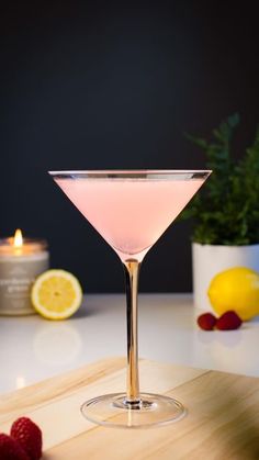 a pink drink sitting on top of a wooden cutting board