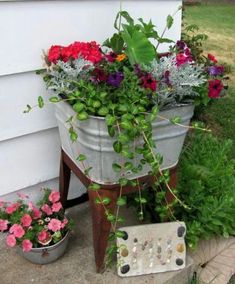 two buckets filled with flowers sitting on the side of a house