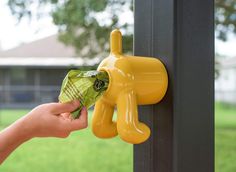 a hand is holding money in front of a yellow water faucet