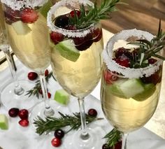 three glasses filled with wine and garnished with fruit