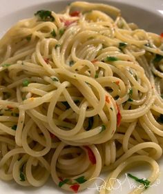 a white plate topped with pasta covered in sauce and parmesan sprinkles