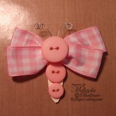 a pink bow with two buttons attached to it