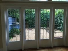 the inside of a house with three doors and two windows that have glass panes on them