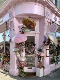 a pink store front with lots of flowers on it