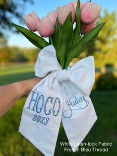 pink tulips are tied to a white bag with the word hoco today on it