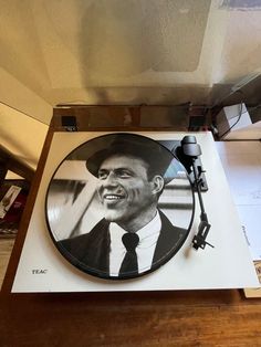 a record player sitting on top of a wooden table next to a microphone and headphones