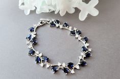 "This glamorous bracelet is loaded with sparkly oval sapphire blue stones, and clear round shaped stones set in a silver plated. setting.  The bracelet would be a perfect accessory for your something blue!  I can design the bracelet with a box clasp and no extender or with an extender. Choose your style at checkout. The bracelet without the extender is 6 1/2\" . The bracelet with the extender will measure 7 1/2\"  including the extender. PACKING:  The bracelet will arrive in a beautiful bow tied gift box. MATCHING EARRINGS https://www.etsy.com/shop/Uniquebeadables?ref=seller-platform-mcnav&search_query=sapphire+earrings ** To view more items in my shop, please click below ** http://www.etsy.com/shop/Uniquebeadables Don't forget to \"LIKE\" Uniquebeadables on FACEBOOK to make sure that you Elegant Sapphire Crystal Bracelets, Elegant Blue Cubic Zirconia Crystal Bracelet, Blue Cubic Zirconia Crystal Bracelet, Blue Crystal Bracelets For Formal Occasions, Blue Crystal Bracelets For Anniversary, Elegant Blue Bracelets With Sparkling Stones, Elegant Blue Crystal Bracelet With Sparkling Stones, Blue Cubic Zirconia Wedding Bracelet, Elegant Blue Jubilee Crystal Bracelet