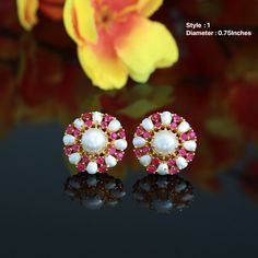 These Earrings are miniature flower-shaped studs with pearl and Semiprecious ruby stones - perfect for daily use or a special outing. They are specifically designed in 22 carat gold plating. This earring is perfect, comfortable, and attractive. You are bound to receive compliments, as this is one of the many other glamorous products created from the house of Indian Designs. Elegant White Ruby Earrings, White Fine Jewelry Earrings For Valentine's Day, Fine White Earrings For Valentine's Day, White Gemstone Round Bridal Earrings, White Valentine's Day Fine Jewelry Earrings, White Gemstone Bridal Earrings For Gift, White Gemstone Bridal Earrings As Gift, White Ruby Round Earrings, Round Ruby Bridal Earrings Gift