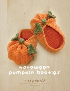 two knitted pumpkins sitting on top of a wooden table