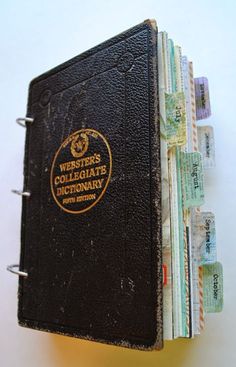 an old book with some notes attached to the front and back cover, sitting on top of each other