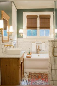 a bath room with a sink a tub and a mirror on the wall in it