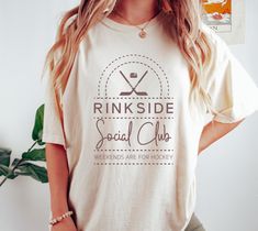 a woman standing in front of a plant wearing a pinkside social club t - shirt