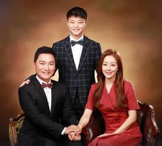 two men and a woman in formal wear posing for a photo