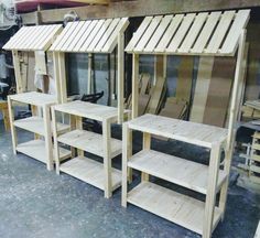 three wooden shelves sitting next to each other in front of a building made out of pallets