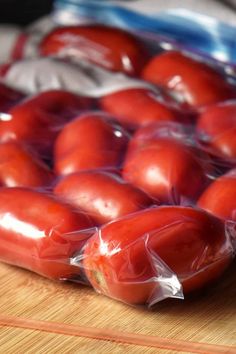 a bag of tomatoes sitting on top of a wooden table