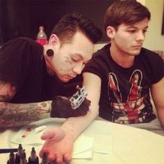 two young men sitting at a table playing chess