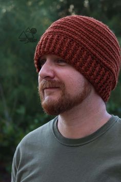 a man with a beard wearing a red knitted hat and looking off to the side