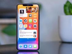 an iphone is sitting on a table next to a potted plant and phone screen