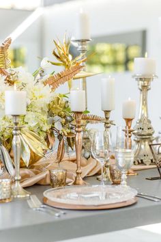 a table with candles, plates and flowers on it