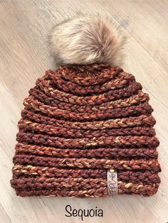 a knitted beanie hat with a pom - pom on the top