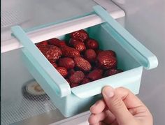 a person holding a container with strawberries in it and another hand reaching for one