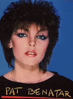 a woman with black hair and blue eyes wearing a t - shirt that says pat benatar