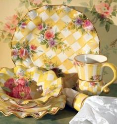 a yellow and white china set with flowers on it