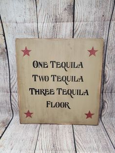 a sign that says, one tequila two tequila three tequila floor on wood planks