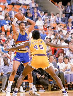 two men playing basketball in front of an audience