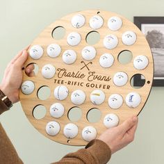 a person holding up a wooden golf board with holes on it and the words charlie evans electric golfer