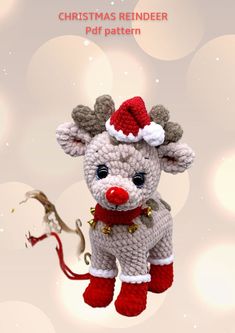 a crocheted christmas reindeer ornament hanging from a string with a red nose and bell