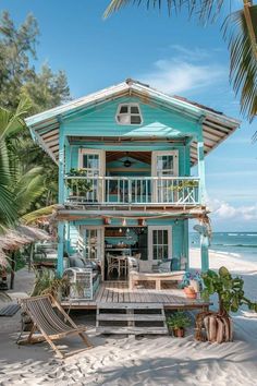 a blue house on the beach with palm trees