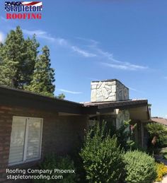 the roof of a house with trees and bushes around it