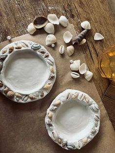 two plates with shells on them sitting next to each other