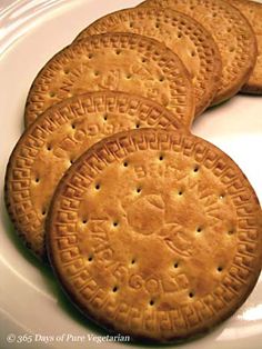 four crackers on a white plate sitting on a table