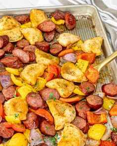 a pan filled with sausage, peppers and potatoes