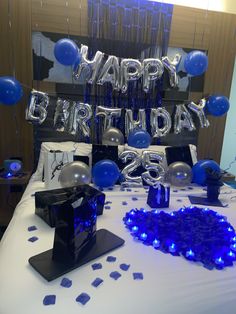 a birthday party with balloons and streamers on the bed, blue confetti